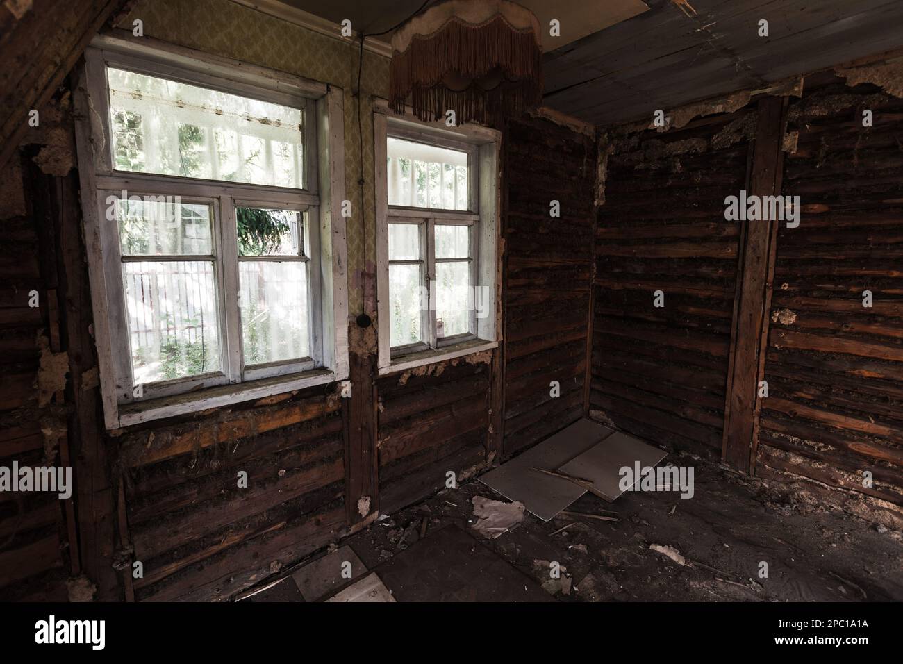 Abstraktes, verlassenes Grunge Interieur, dunkles Holzzimmer mit zwei leeren Fenstern Stockfoto