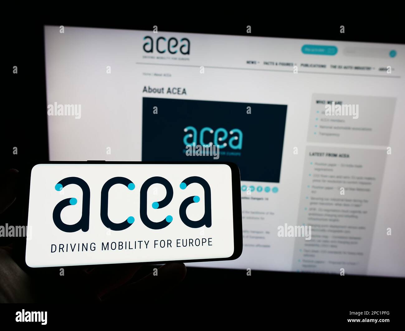 Person, die ein Mobiltelefon mit dem Logo des Europäischen Automobilherstellerverbands (ACEA) auf dem Bildschirm mit der Webseite hält. Konzentrieren Sie sich auf das Display des Telefons. Stockfoto