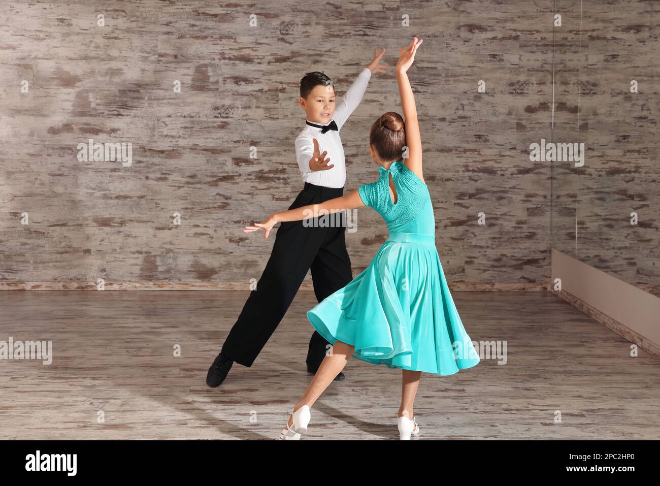 Wunderschön gekleidete Kinder, die zusammen im Studio tanzen Stockfoto