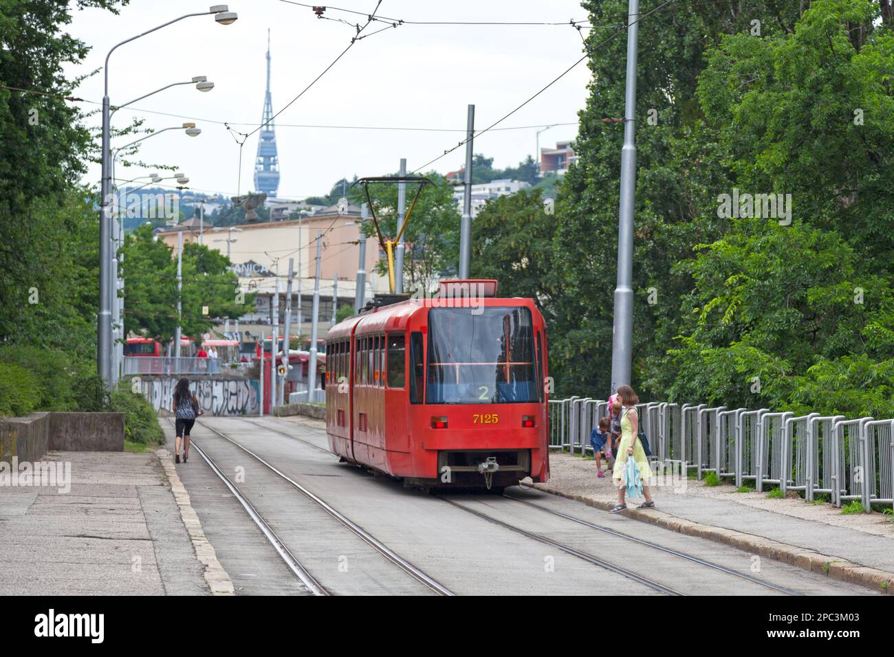 Bratislava, Slowakei - Juni 18 2018: Rote Straßenbahn der Linie 2 zum nahe gelegenen Bahnhof mit dem Fernsehturm Kamzík dahinter. Stockfoto