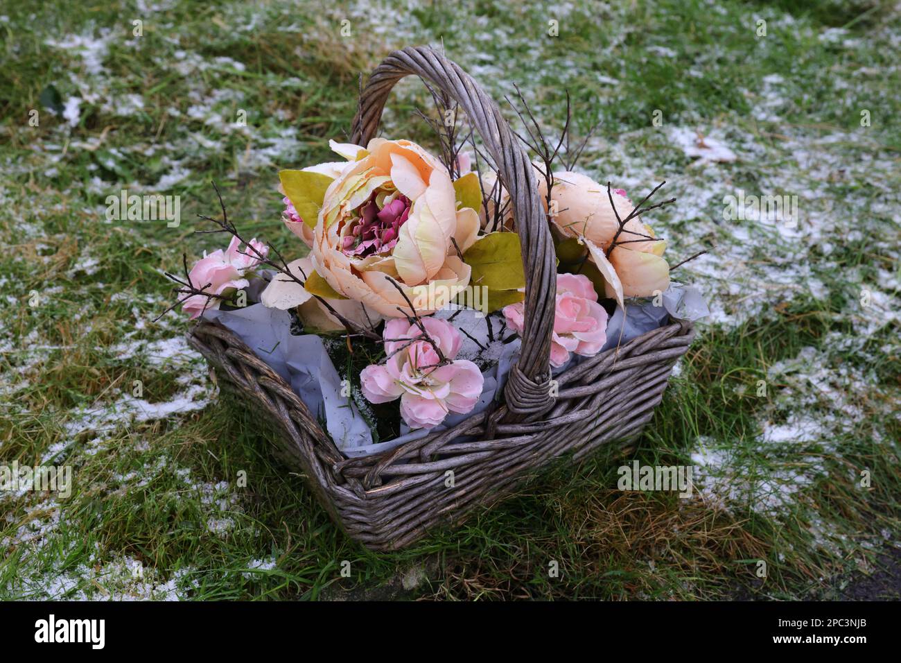 Korb voller künstlicher Blumen. Stockfoto