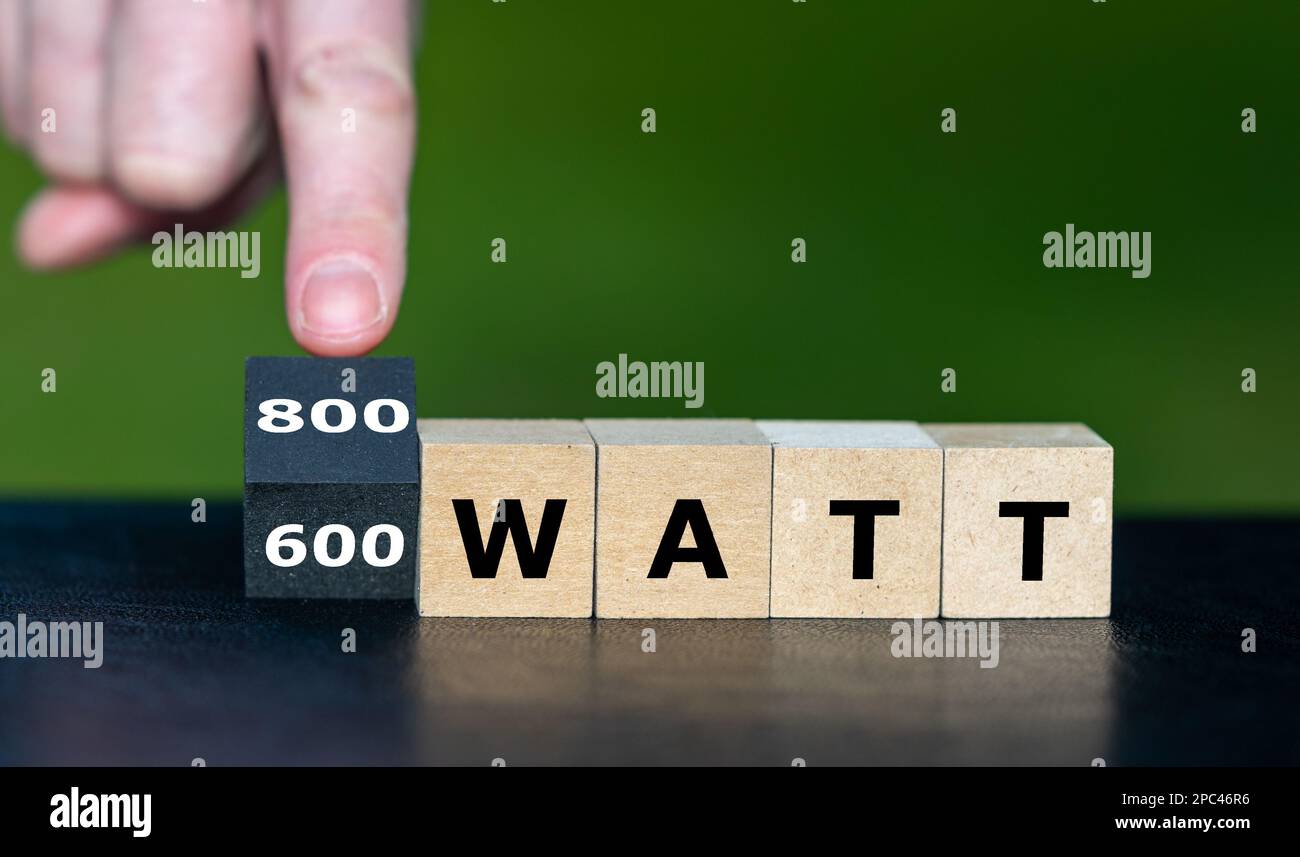 Symbol zur Verwendung eines 800 Watt Solarmoduls ohne Zulassung in Deutschland. Die Hand dreht den Würfel und ändert den Ausdruck „600 Watt“ in „800 Watt“. Stockfoto