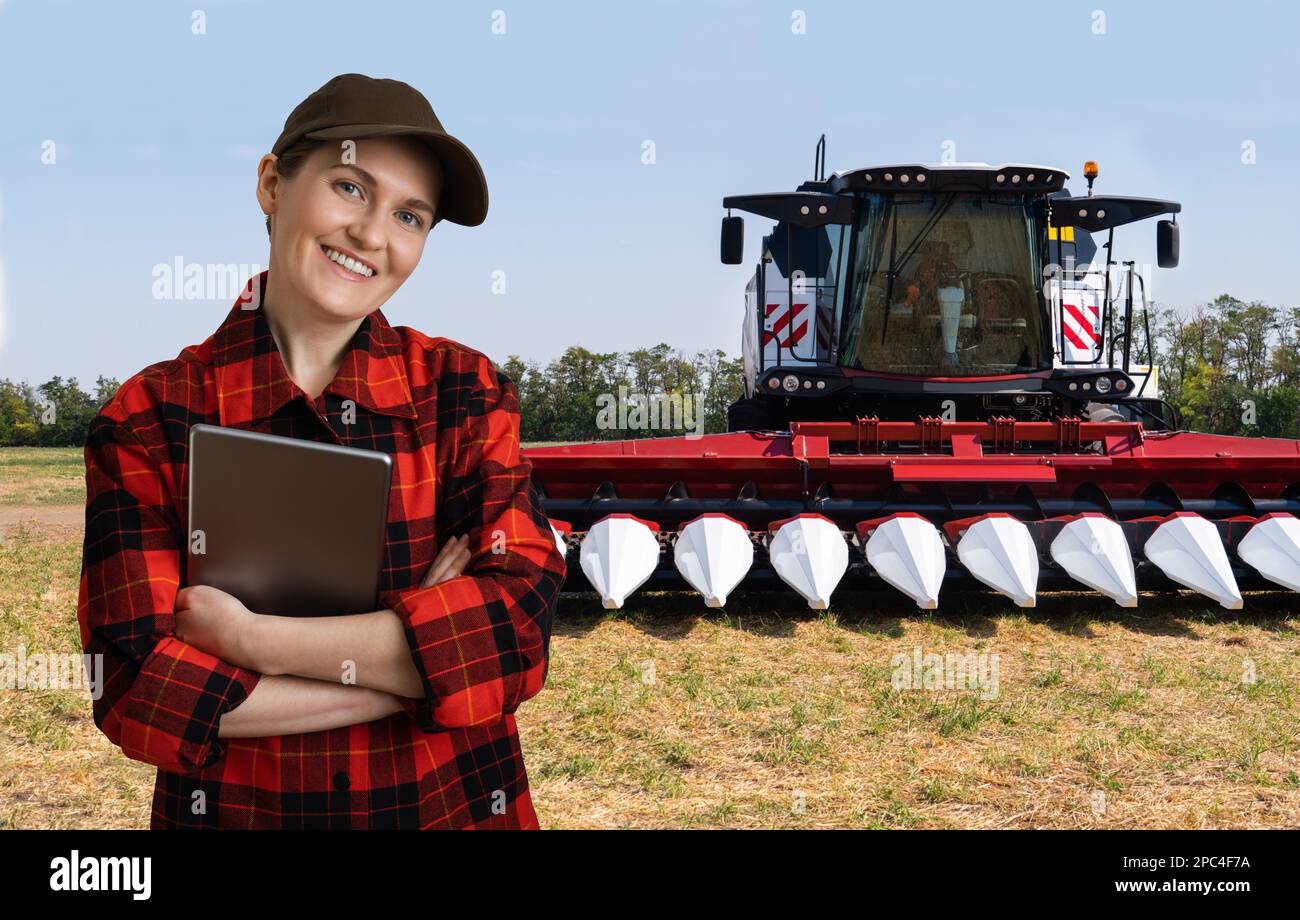 Landwirt mit digitalem Tablet auf dem Hintergrund des Mähdreschers. Smart Farming-Konzept. Stockfoto