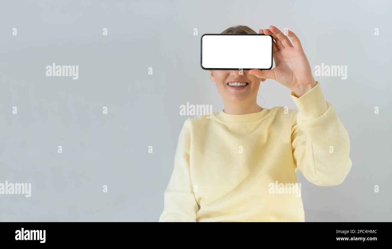 Eine Frau, die ein leeres Smartphone in der Hand hält. Stockfoto