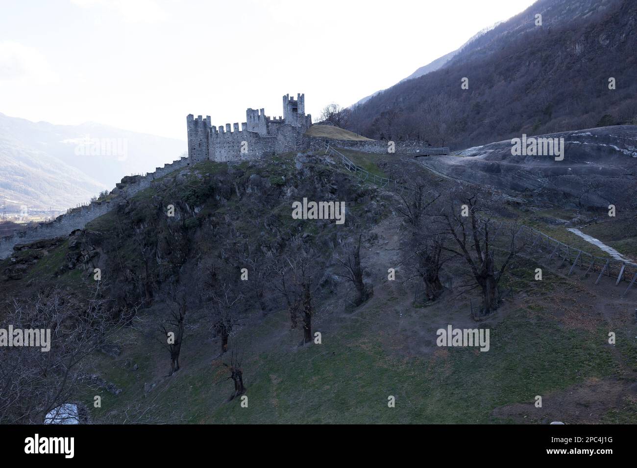 Valtellina, Italien - 12. März 2023: Straßenblick auf die alten Mauern rund um das alte Schloss in Grosio, eine Festung in Ruinen. Es sind keine Personen sichtbar. Stockfoto