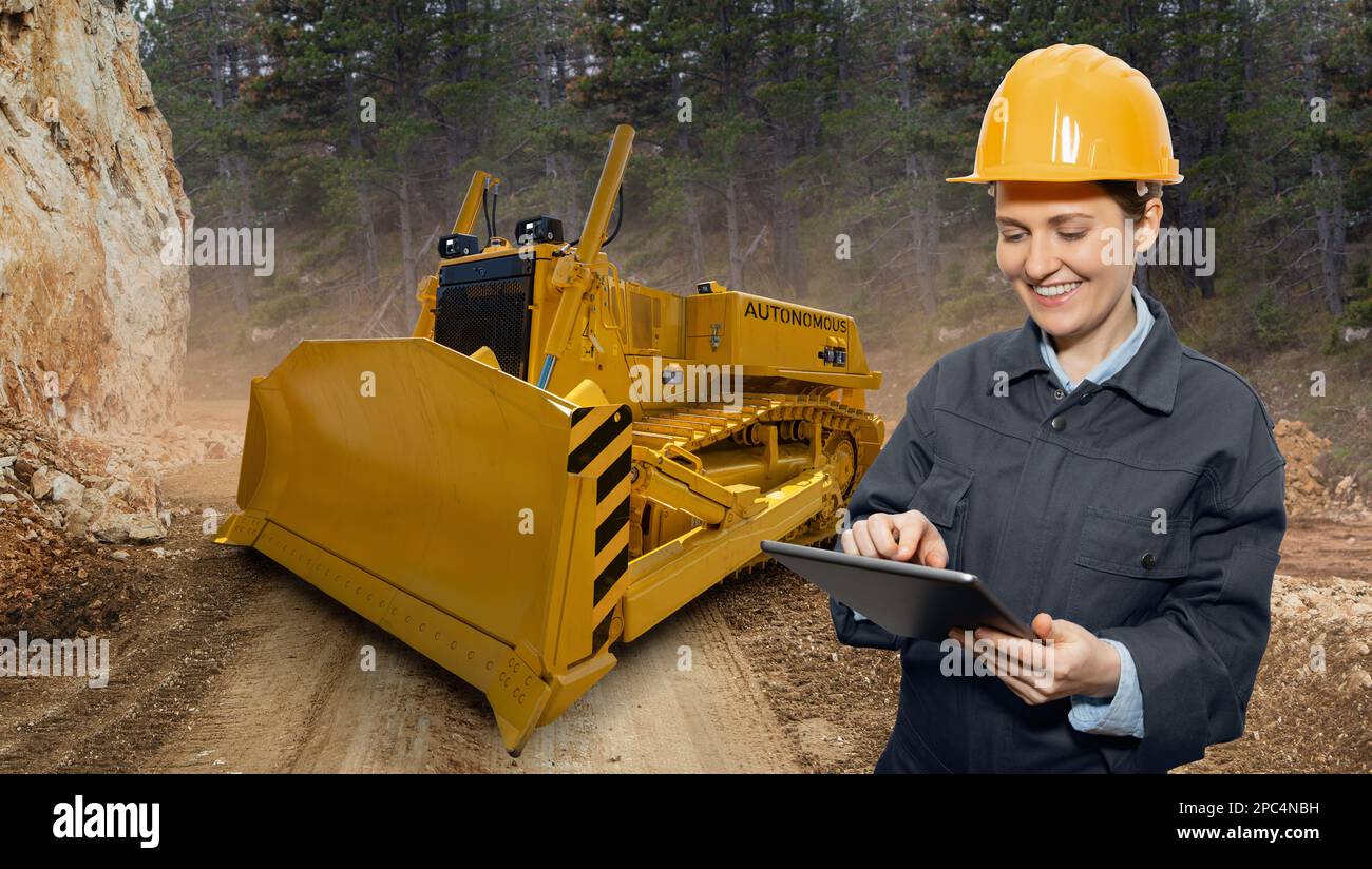 Ingenieur Programme autonomen Bulldozer mit digitalen Tablet Stockfoto