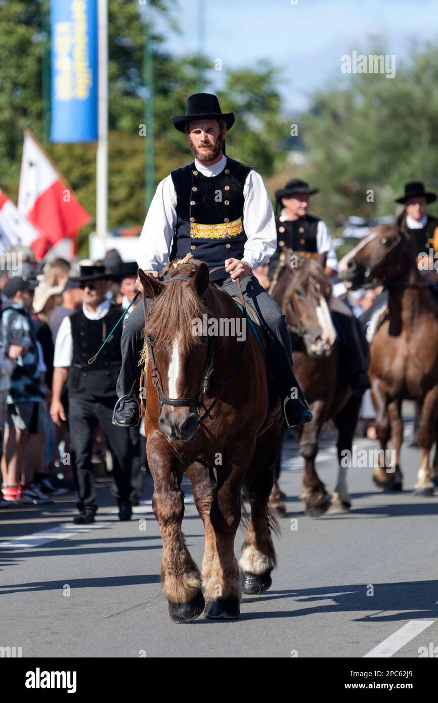Quimper, Frankreich - Juli 24 2022: Reiter in traditioneller bretonischer Kleidung auf einem Postier Breton während des Cornouaille Festivals. Stockfoto
