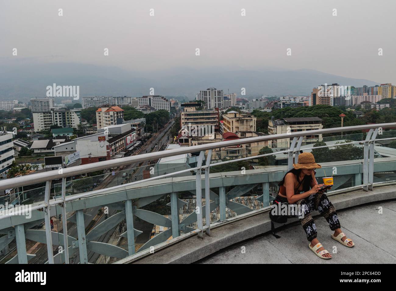 Chiang Mai, Thailand. 13. März 2023. Touristen auf dem Dach des Gebäudes in Chiang Mai, das von der Luftverschmutzung überrannt wird. Chiang Mai wurde mit einer PM2,5-Konzentration von mehr als 100,3 µg/m³ die größte verschmutzte Stadt der Welt, die mehr als das 20-Fache des jährlichen LUFTQUALITÄTSLEITWERTS DER WHO beträgt. Die Stadt wurde von dem Nebel der Luftverschmutzung bedeckt, die gesundheitliche Auswirkungen haben könnte. Kredit: SOPA Images Limited/Alamy Live News Stockfoto