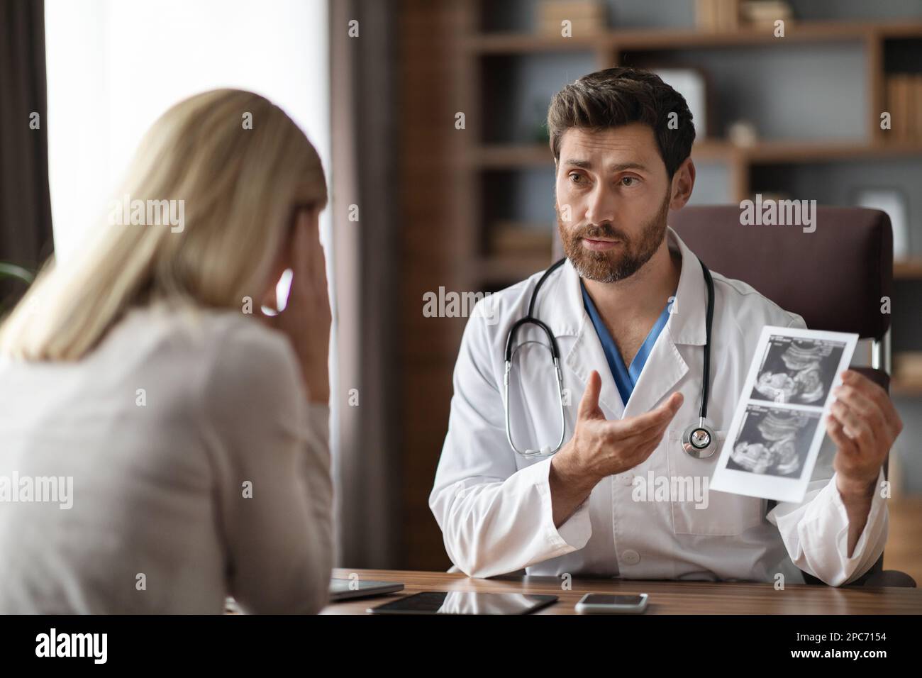 Männlicher Gynäkologe Arzt, Die Schwangere Patientin In Der Klinik Konsultiert Stockfoto