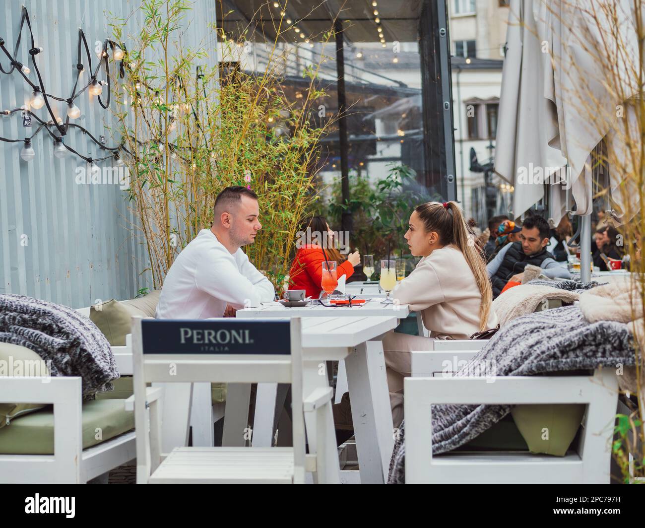 Bukarest, Rumänien - August 2023: Urbane Szene mit Menschen, die an Tischen sitzen und einen Drink in der Altstadt von Bukarest genießen Stockfoto