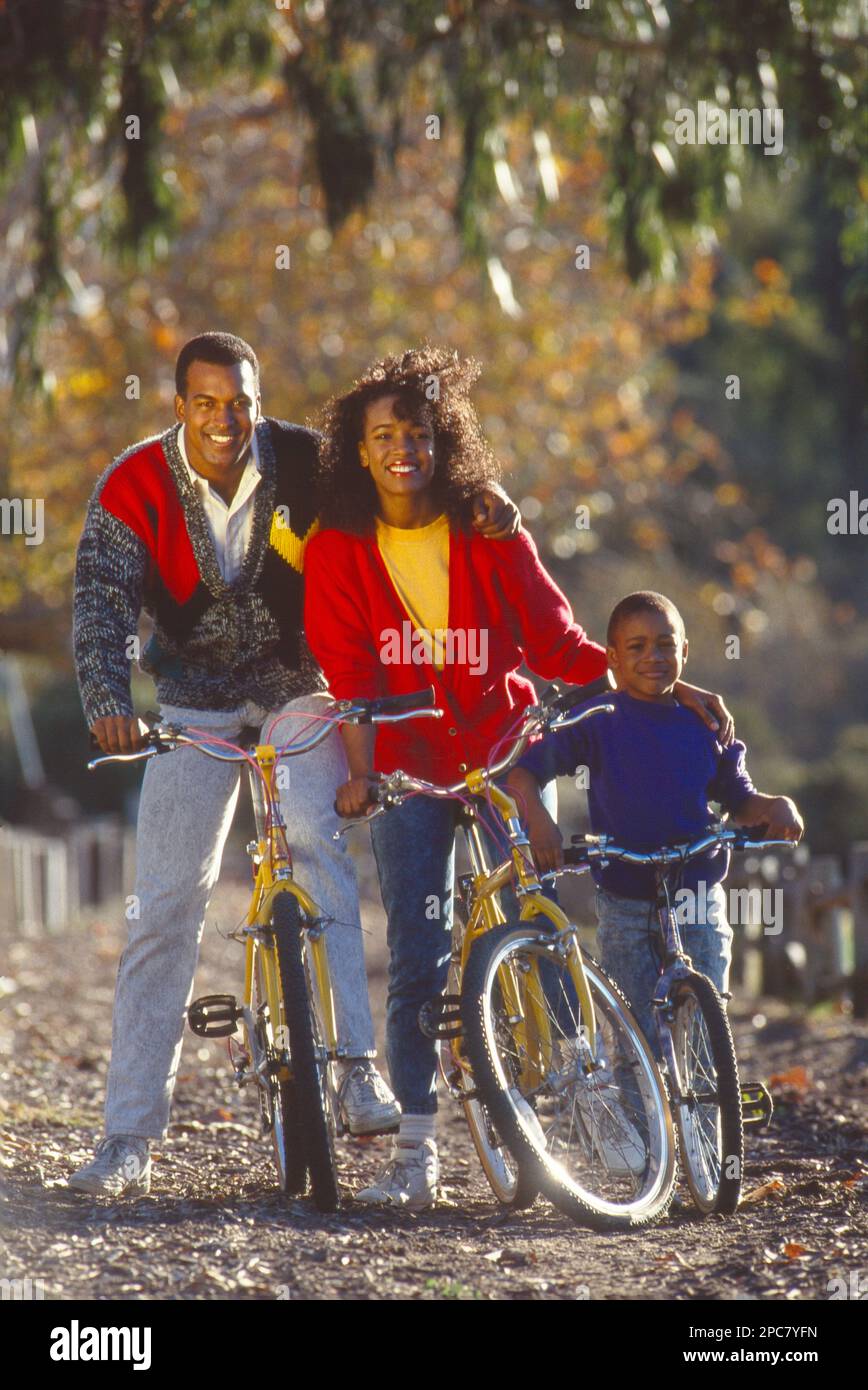 Junge afroamerikanische Familie, Mutter, Vater und Sohn posierten für ein Foto, während sie Fahrrad fuhren Stockfoto