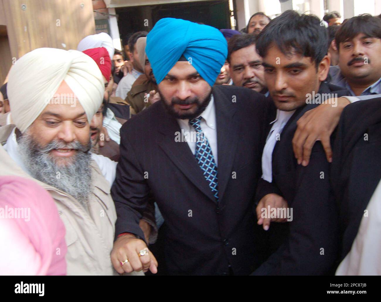 Former Indian cricket player turned politician Navjot Singh Sidhu,in blue turban, coming out of Punjab and Haryana High Court in Chandigarh, India,Wednesday, Dec.6, 2006. The court on Wednesday sentenced Sidhu to three years in prison for killing a person during a scuffle triggered by a car parking argument in 1988, news reports said.(AP Photo) Stockfoto