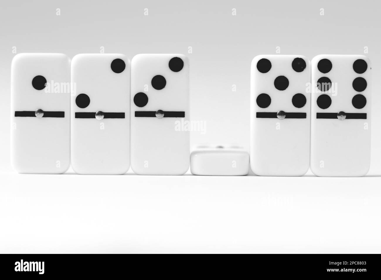 Domino-Effekt für Geschäftsideen, ein Peice Dominosteine im weißen Hintergrund mit negativem Raum, Strategie und erfolgreichen Interventionen, Brettspiel, und Stockfoto