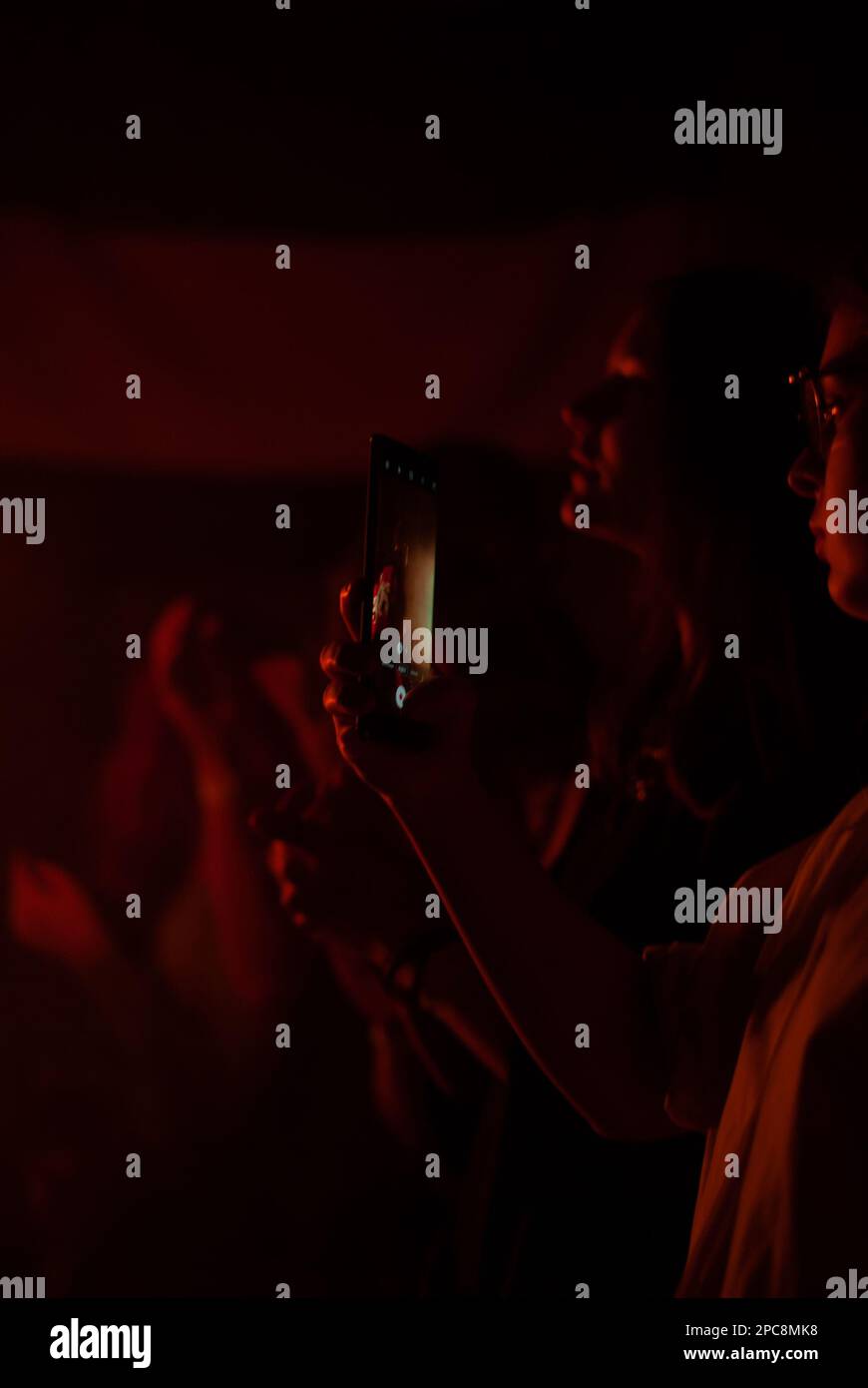 Blick auf die Menschenmenge im Nachtclub in roten Lichtern Stockfoto