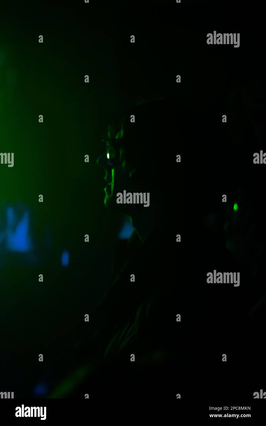 Blick auf die Menschenmenge im Nachtclub in grünen Lichtern Stockfoto