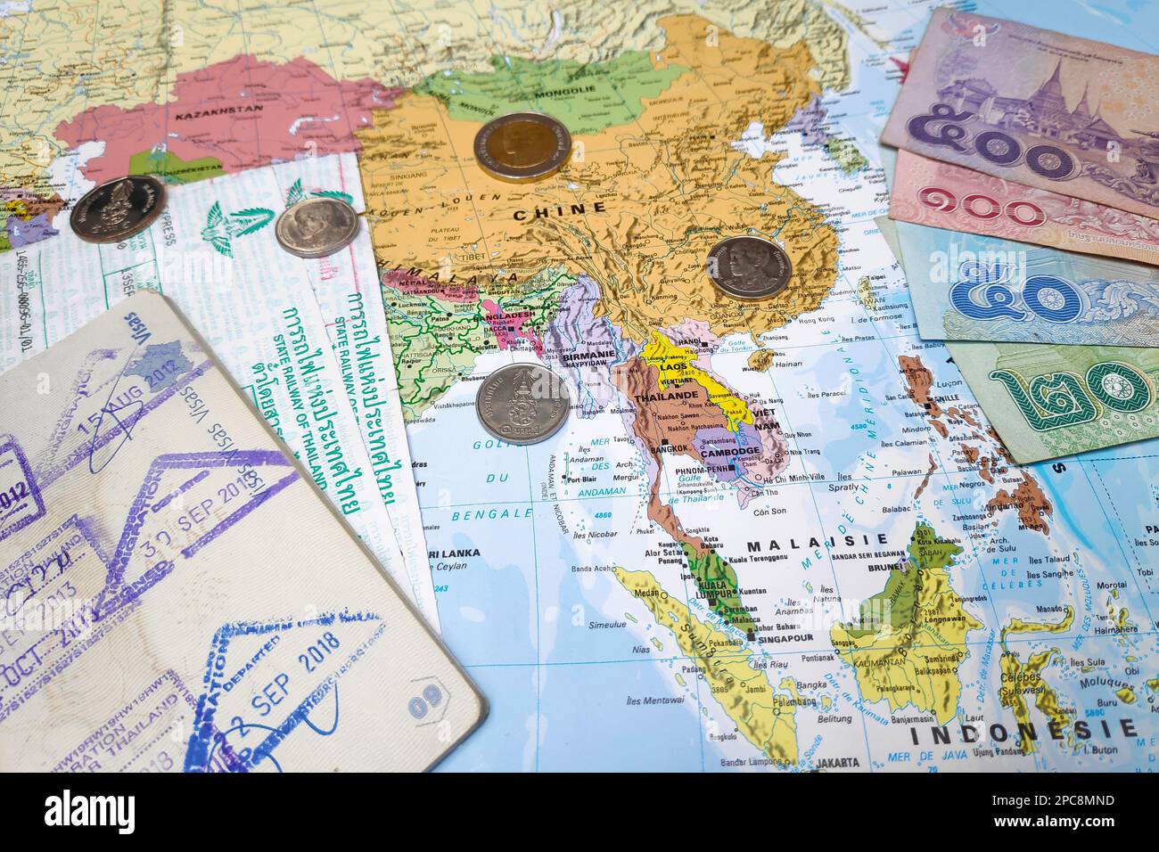 Bangkok, Thailand - Februar 19 2019: Komposition aus einer Weltkarte, die sich in Südostasien befindet und auf der einige thailändische Baht-Banknoten und -Münzen als Schmuckstück stehen Stockfoto