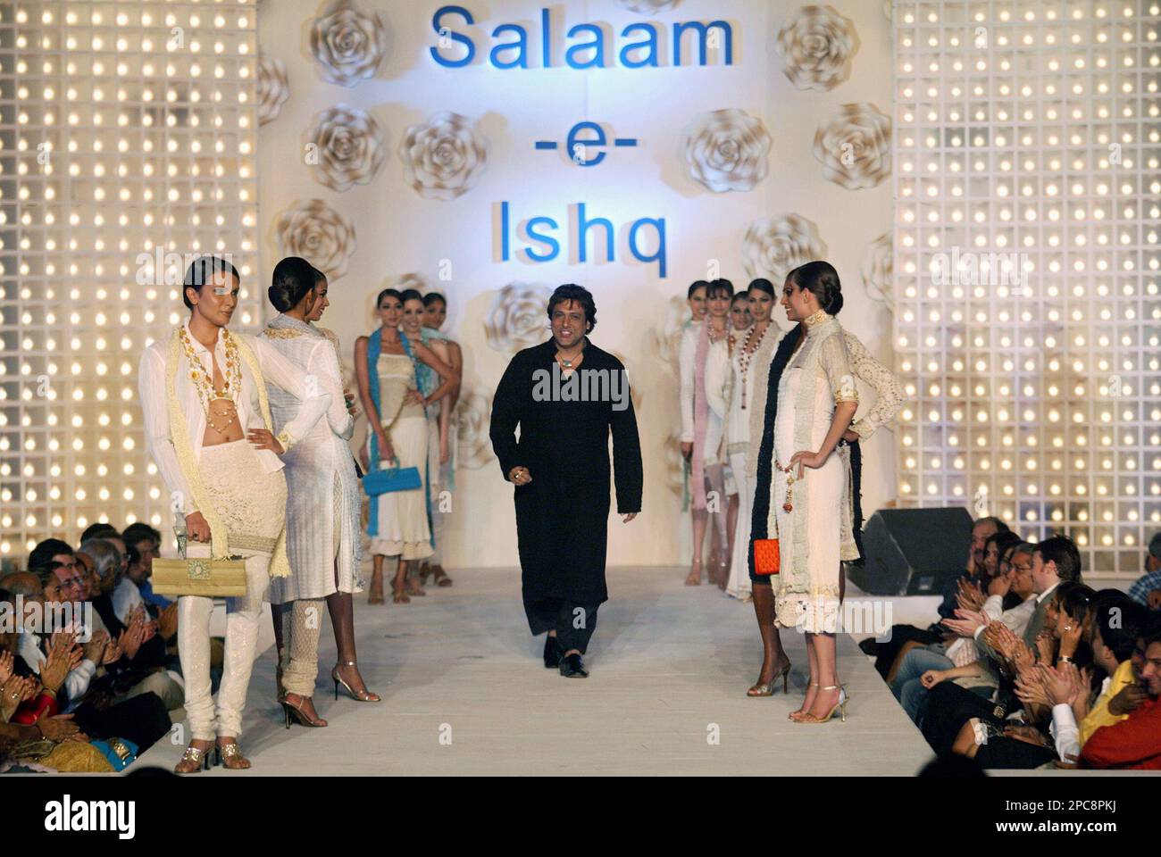 Bollywood actor Govinda, center, walks the ramp as models look on during a fashion show held at the launch of the music of Bollywood film 'Salaam-e-Ishq' ('A Salute to Love') in Mumbai, India, Saturday, Dec. 2, 2006. (AP Photo/Gautam Singh) Stockfoto