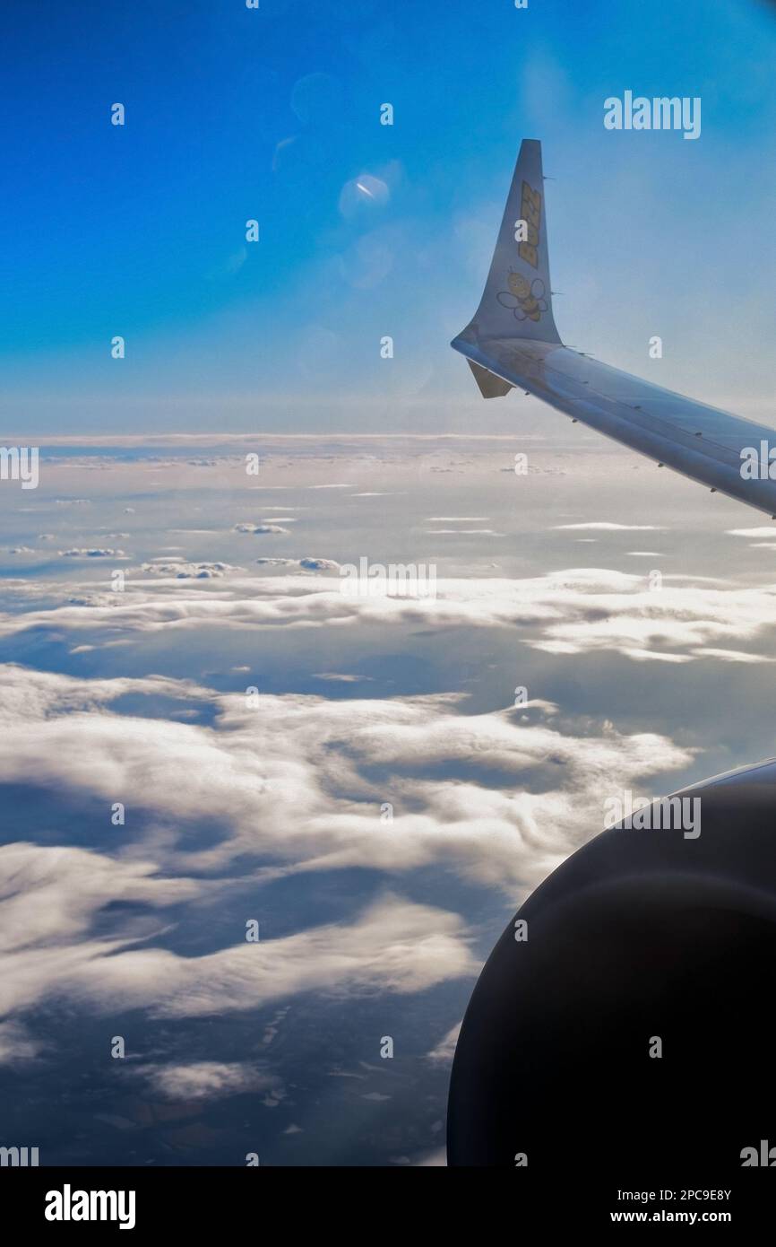 Flugzeugflügel am Himmel, Flugzeug über Wolken Berge und Städte, wunderschönes Foto von Flugreisen. Stockfoto