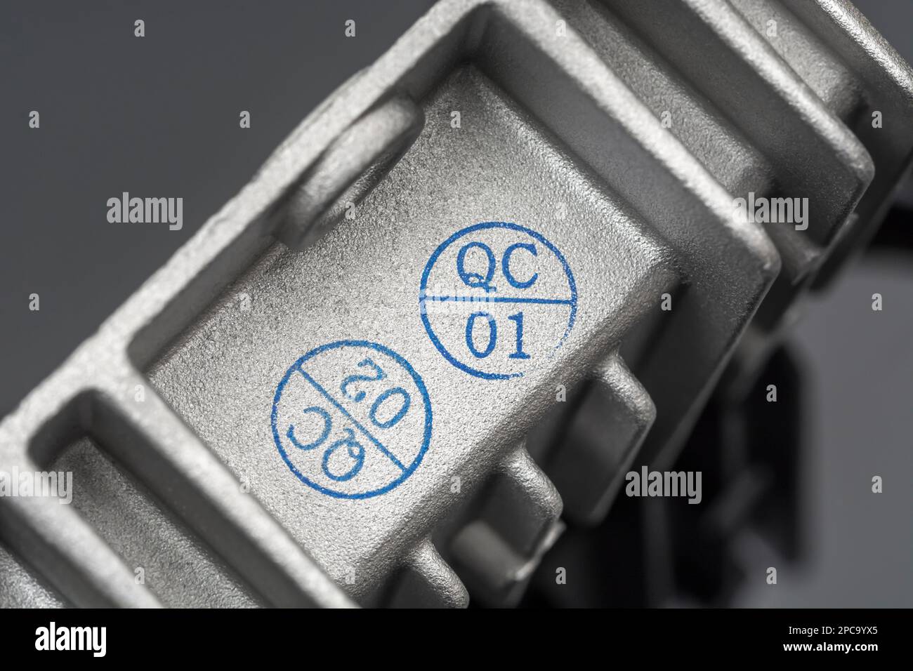 QC-/Qualitätskontrollstempel auf einem chinesischen DC/DC-Ladewandler aus Aluminiumdruckguss ohne Marke mit Wärmeleitflossen. Für gefertigte Elektrogeräte. Stockfoto