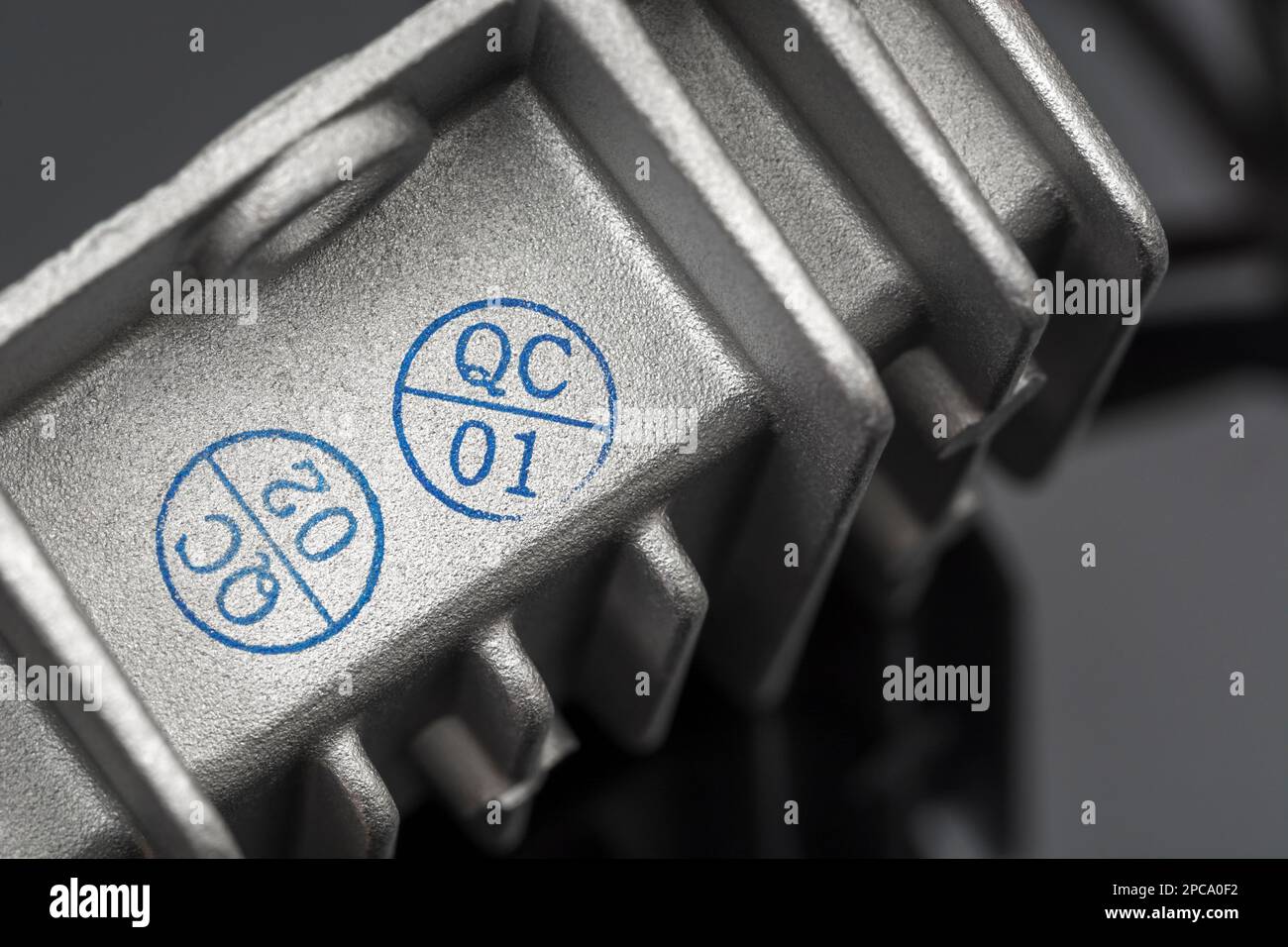 QC-/Qualitätskontrollstempel auf einem chinesischen DC/DC-Ladewandler aus Aluminiumdruckguss ohne Marke mit Wärmeleitflossen. Für gefertigte Elektrogeräte. Stockfoto