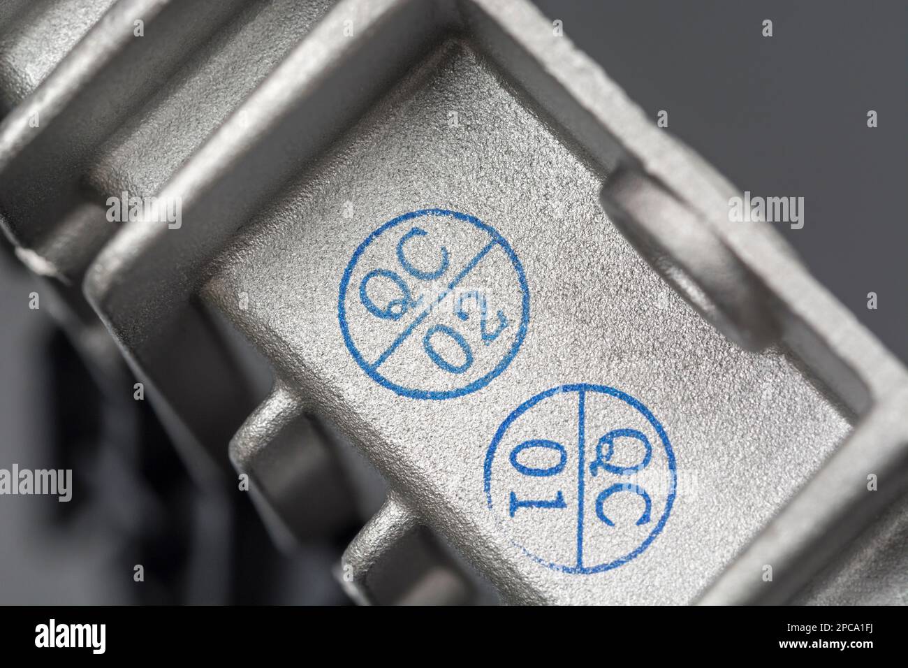 QC-/Qualitätskontrollstempel auf einem chinesischen DC/DC-Ladewandler aus Aluminiumdruckguss ohne Marke mit Wärmeleitflossen. Für gefertigte Elektrogeräte. Stockfoto