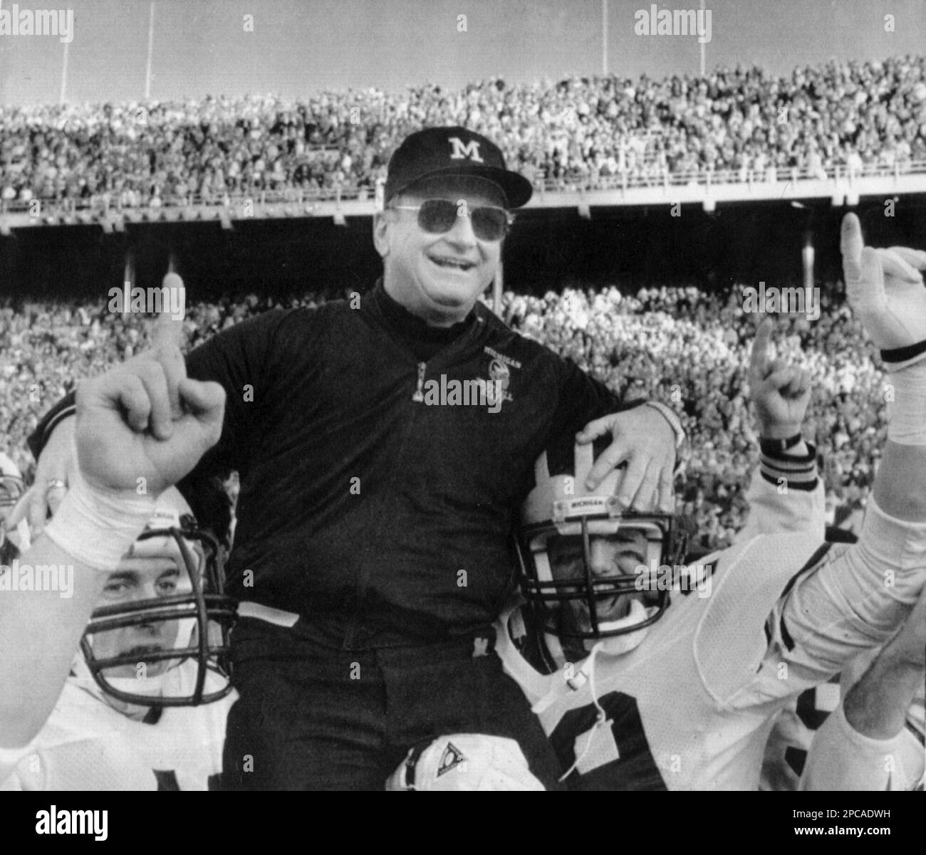 ** FILE ** Michigan coach Bo Schembechler is carried from the field in this Nov. 22, 1986, in Ann Arbor, Mich, after a 26-24 victory over Ohio State for the Big Ten title and a trip to the Rose Bowl on New Year's Day. Schembechler, who became one of college football's great coaches in two decades at Michigan, died Friday after taping a TV show on the eve of the Wolverines' No. 1 vs. No. 2 showdown with perennial rival Ohio State. He was 77. (AP Photo/Mark Duncan) Stockfoto