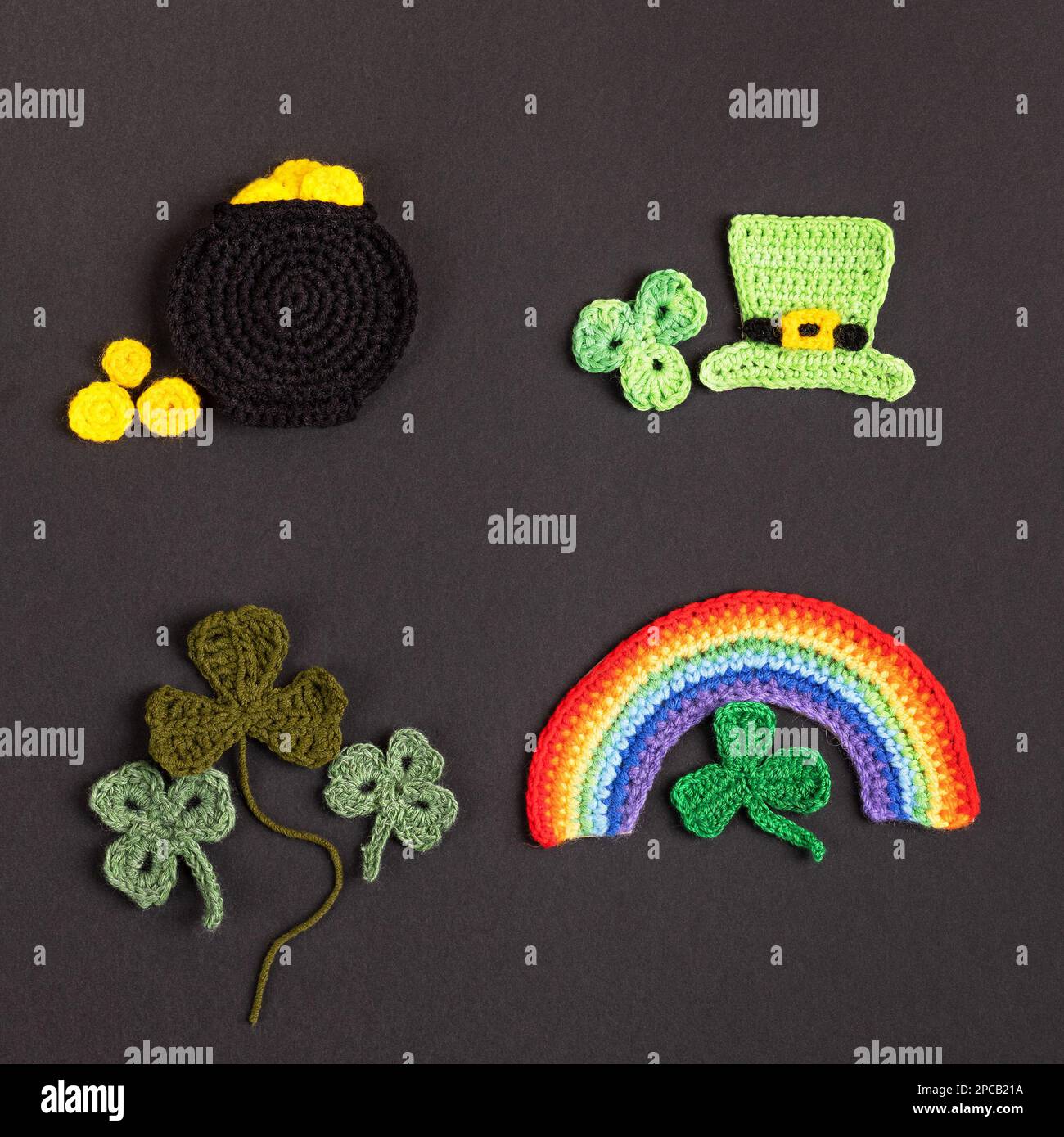 St. Patrick's Day Konzept. Gestrickte Komposition aus grünem Hut, goldenem Topf, Regenbogen und grünen Shamrocks auf schwarzem Hintergrund Stockfoto