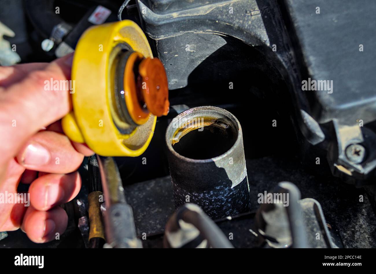 Mechaniker öffnen von Hand einen Öleinfüllverschluss des Motorwagens Stockfoto