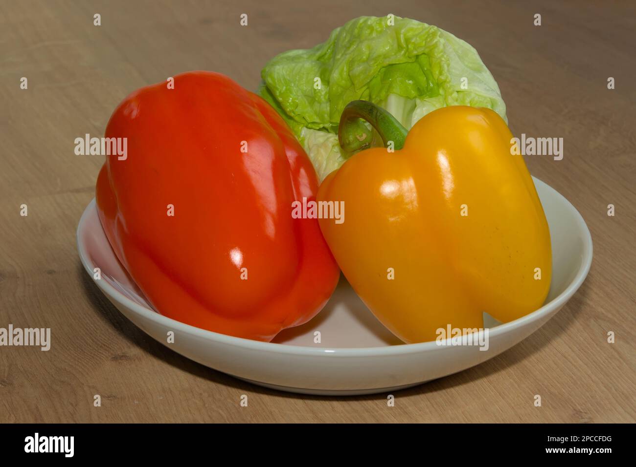 Roter Pfeffer oder Paprika, gelber Pfeffer oder Paprika und grüner Salat sind sehr gesunde Lebensmittel. Das Gemüse ist die perfekte Zutat für eine leckere Mahlzeit. Stockfoto