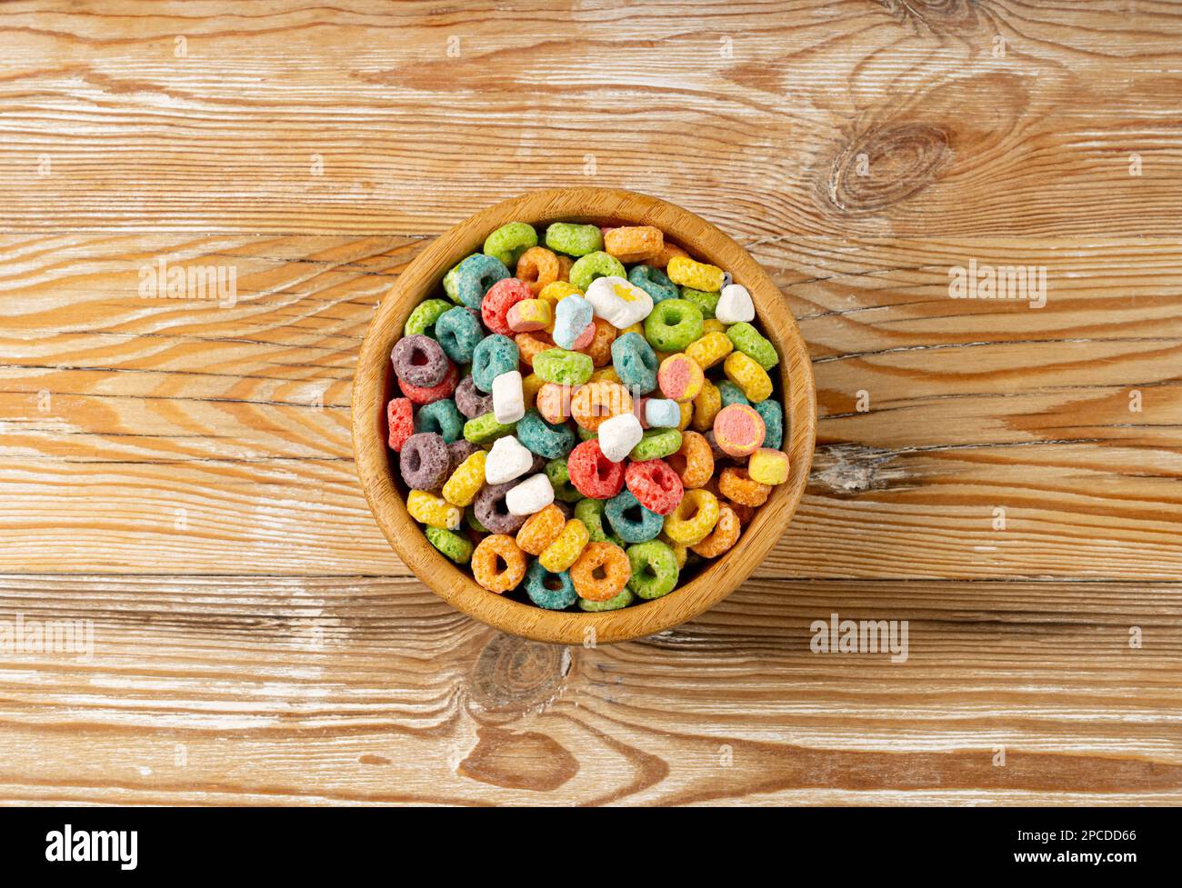 Bunte Frühstücksringe, Fruit Loops, fruchtige Cerealien-Ringe mit Marshmallows, bunte Corn Cerealien auf Holzhintergrund Stockfoto