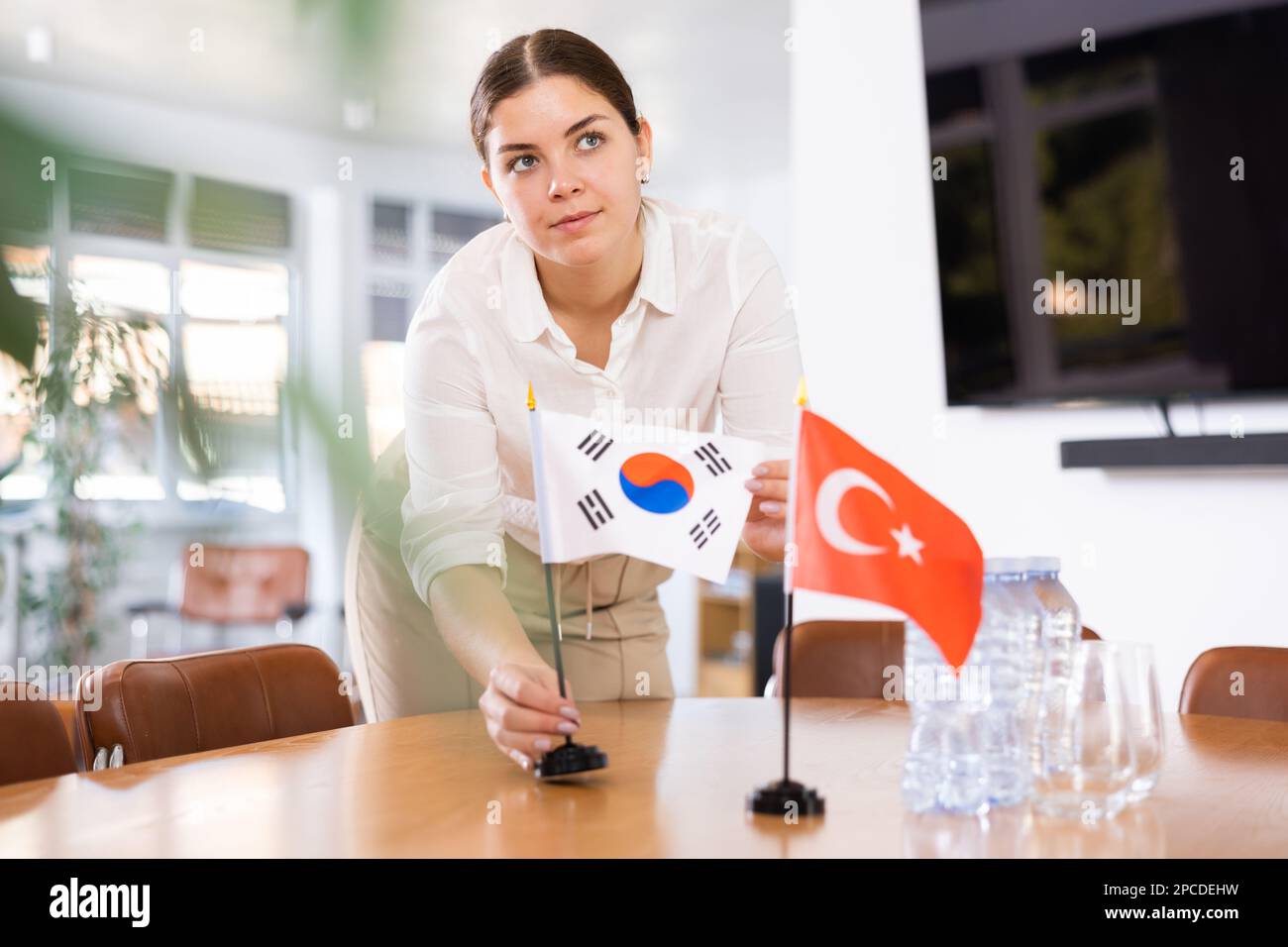 Weibliche Assistentin bereitet Konferenzraum für Diplomaten aus der Türkei und Südkorea vor Stockfoto