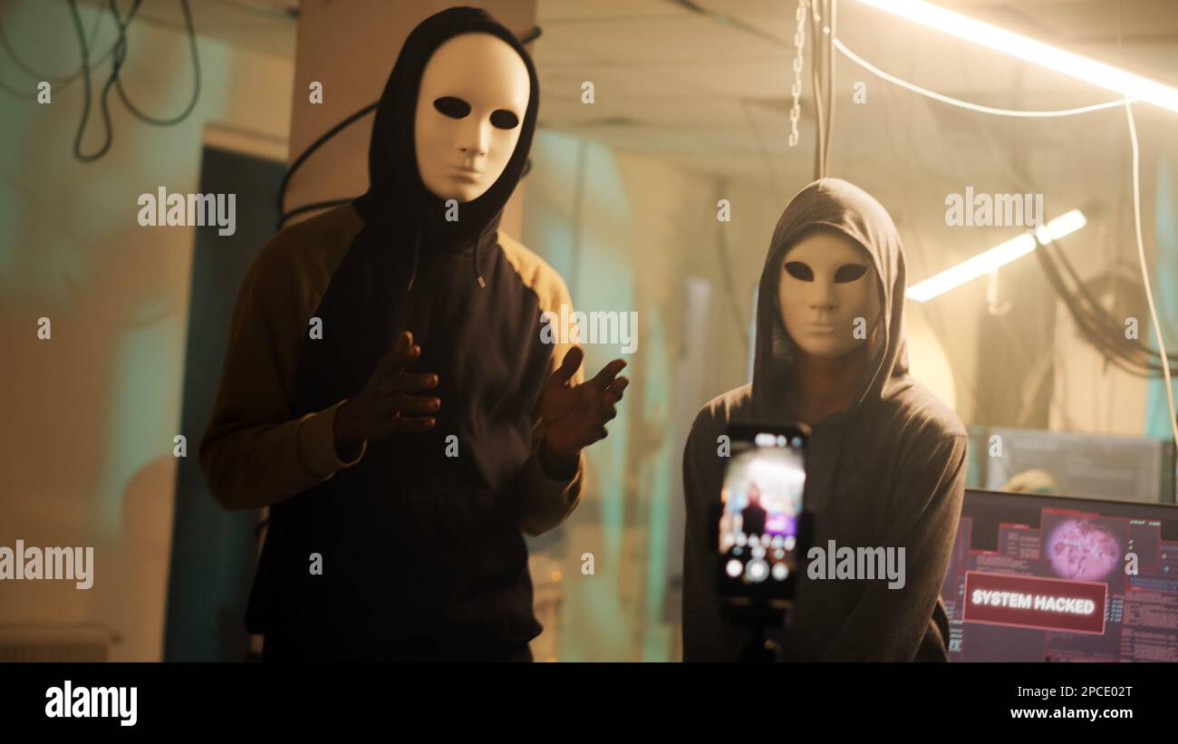 Ein Team anonymer Diebe sendet Drohnenvideos und fragt nach Passwörtern, Ransomware, anstatt Daten zu verbreiten. Hacker mit Masken drohen, Regierungsinformationen preiszugeben. Handgeführte Aufnahme. Stockfoto
