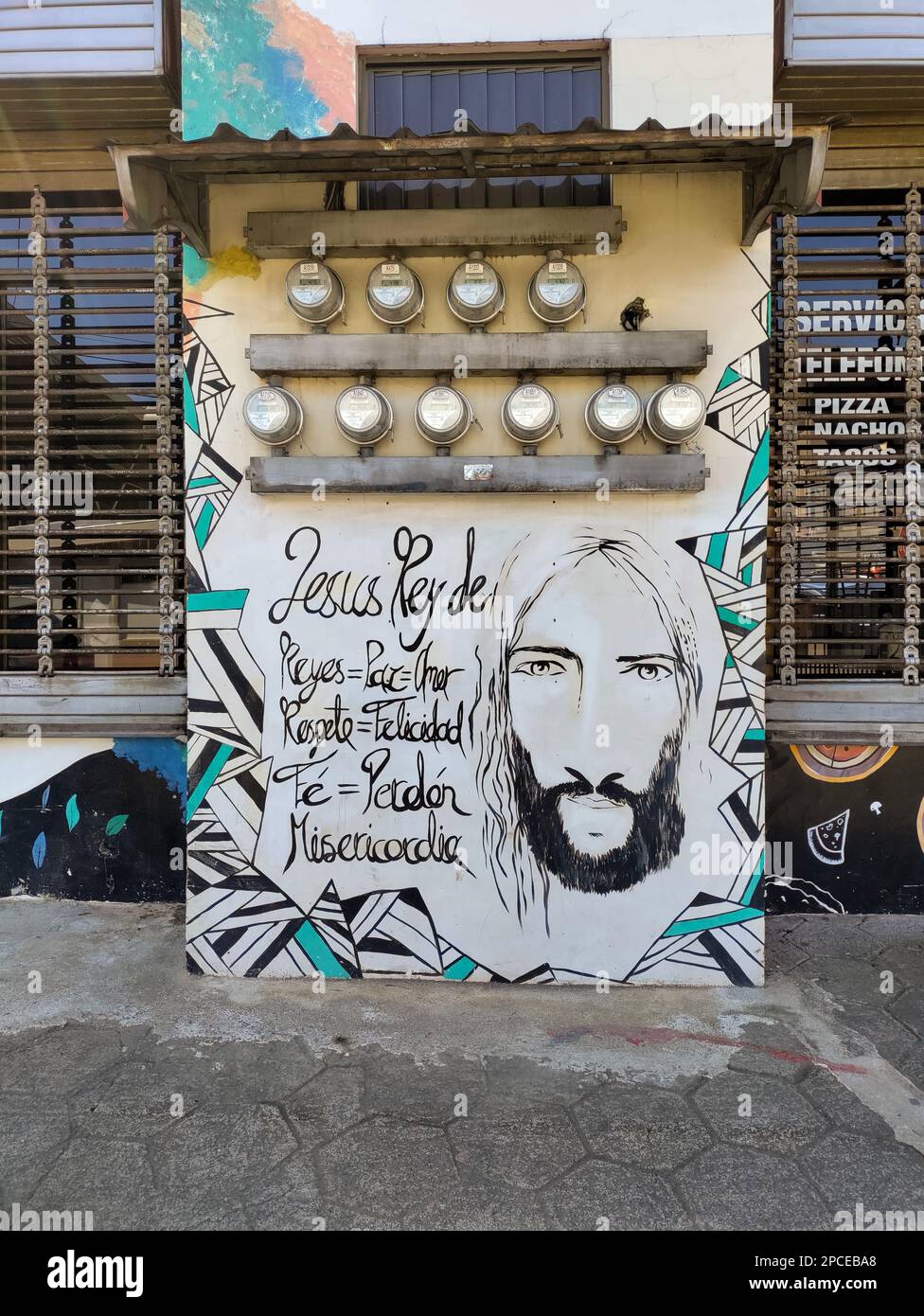 Zarcero, Costa Rica - Kunstwerke über Jesus, die unter den elektrischen Zählern an der Wand eines Gebäudes gemalt wurden. Stockfoto