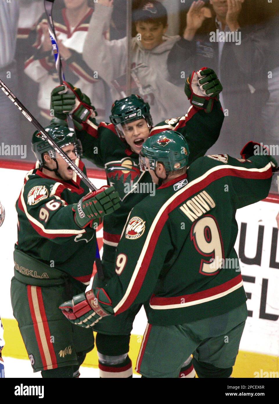 Minnesota Wild's Pierre-Marc Bouchard, left, and Mikko Koivu, right, of Finland, celebrate after Kim Johnsson, center, of Sweden, scored a goal off Washington Capitals goalie Brent Johnson during the first period of an NHL hockey game Thursday, Oct. 12, 2006, in St. Paul, Minn. (AP Photo/Jim Mone) Stockfoto