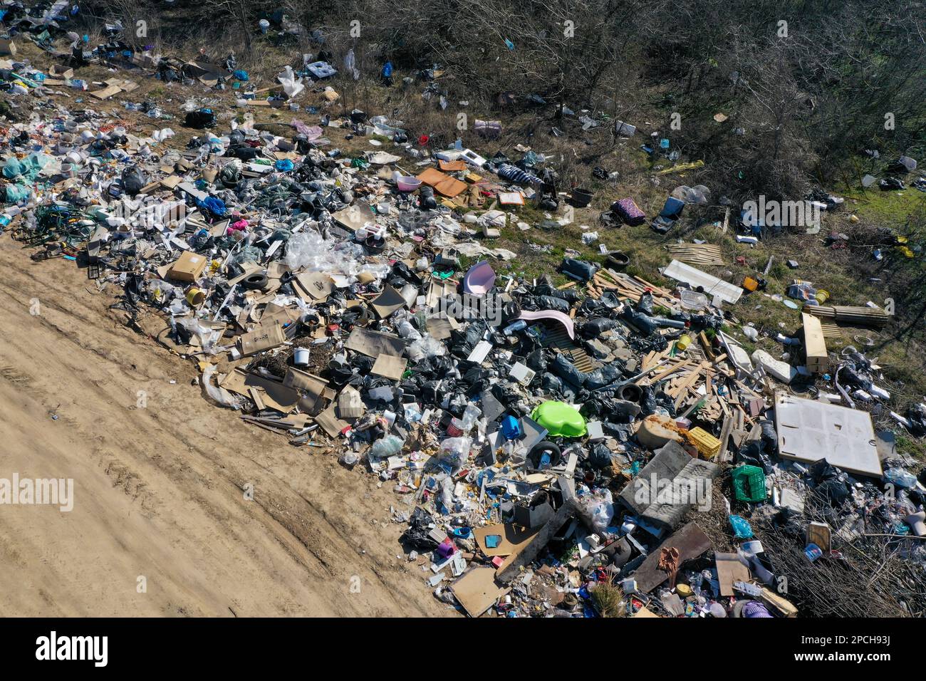 Erstaunliche Umweltverschmutzung in Ungarn. In der Nähe einer Stadt liegt eine Menge Müll neben einer unbefestigten Straße an der Grenze. Umweltverschmutzung. Illegales Dumping. Stockfoto