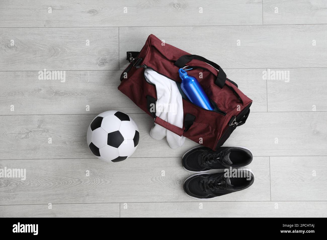 Sporttasche mit Trainingszeug und Ausrüstung auf weißem Boden, flach liegend Stockfoto