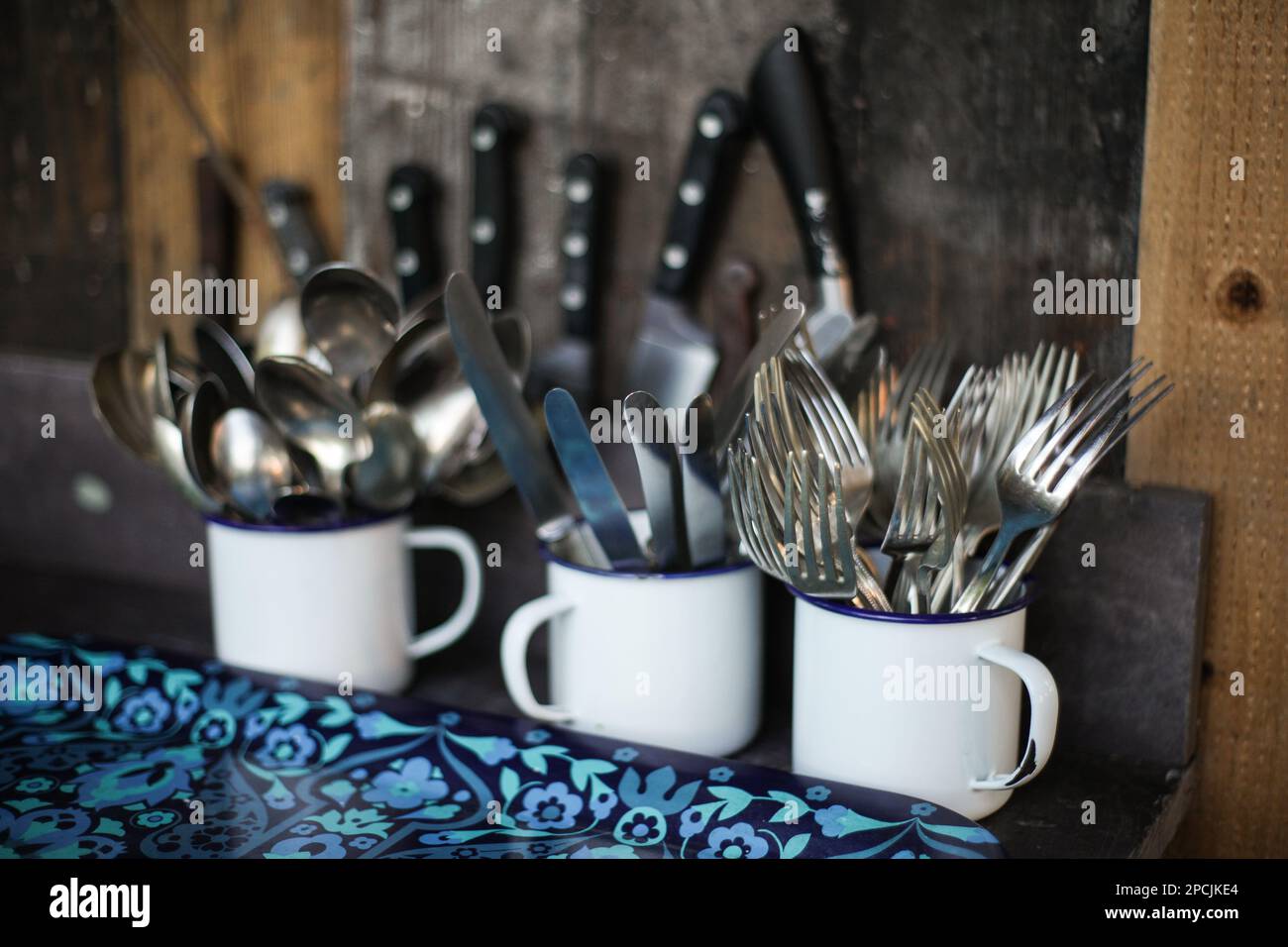 Emaillierte Becher voller Besteck Stockfoto