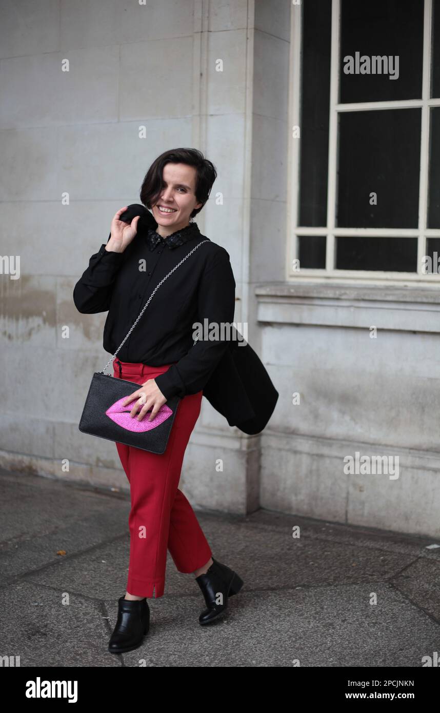 Eine Frau in einer Abendjacke und einer roten Hose Stockfoto