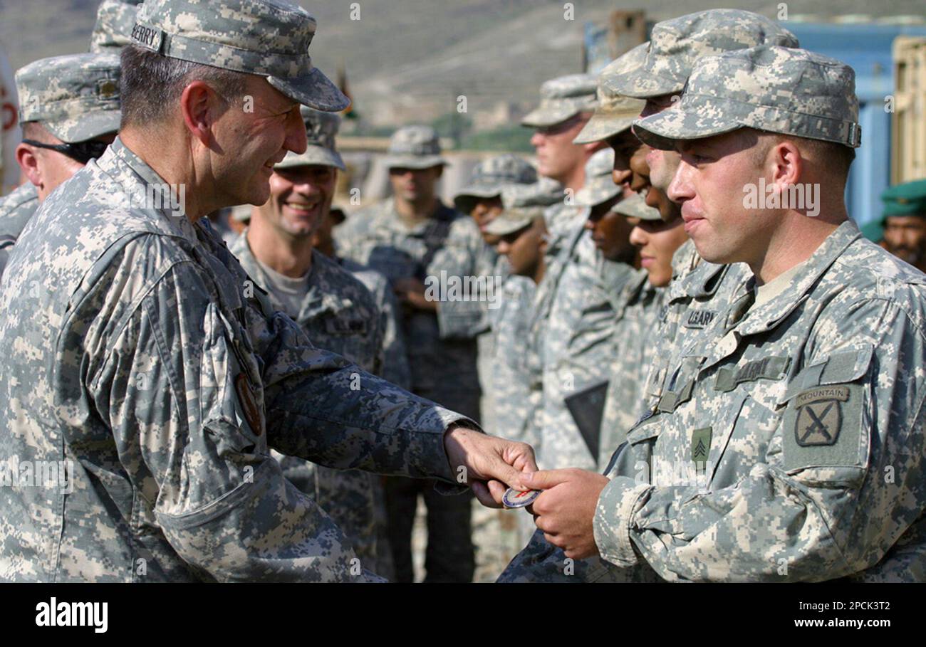 U.S. Lt. Gen. Karl Eikenberry, left, gives sovieners to his soldiers during a visit to Naray military base in northen Afghanistan on Aug 10, 2006. Hundreds of American soldiers at this remote outpost are keeping up the hunt for Osama bin Laden even though the trail's gone cold, still motivated by memories of the hijacked and crashed airliners of five years ago on Sept. 11. (AP Photo/B.K.Bangash) Stockfoto