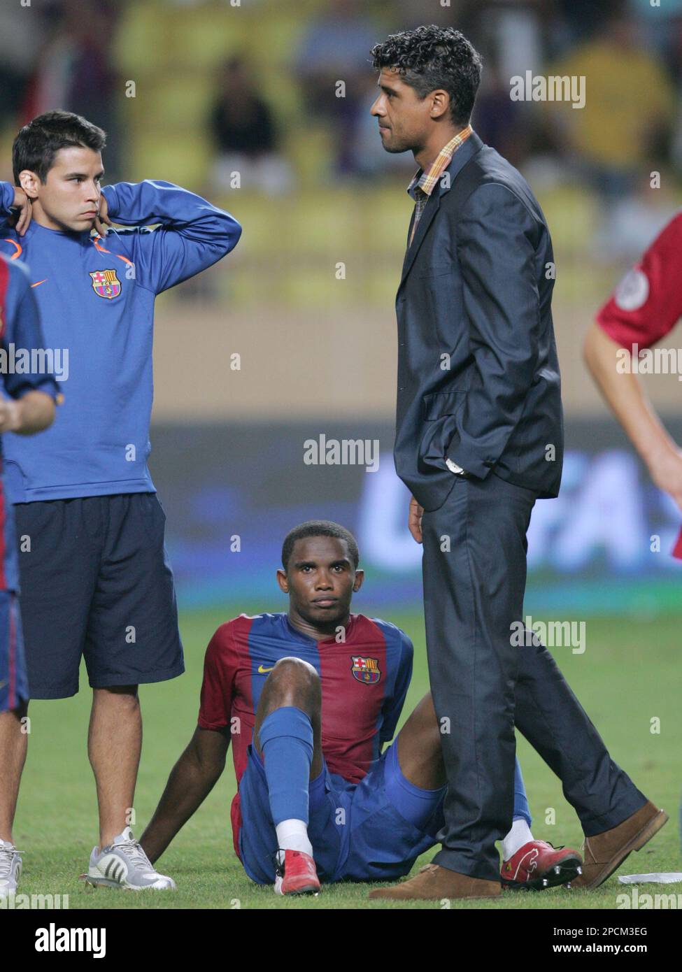 FC Barcelona player Samuel Eto'o, from Cameroon, right, and his teammate Javier Saviola, from Argentina, left, look on as coach Frank Rijkaard, from Netherlands, walks past, after Sevilla defeated Barcelona 3-0 during the UEFA Super Cup at the Stadium Louis II in Monaco, Friday Aug. 25, 2006. (AP Photo/Tomohiko Suzui) Stockfoto