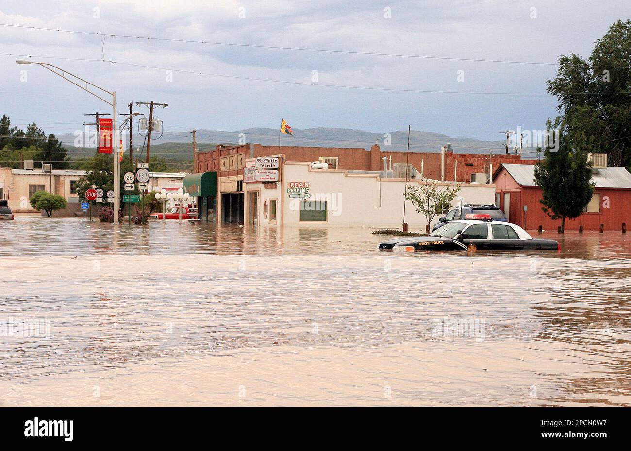 A New Mexico State police car sits stranded in flood waters in downtown Hatch, N.M., as residents continue to flee their homes Tuesday, Aug. 15, 2006, after another day of heavy rain breached an arroyo north of Hatch and flooded parts of the southern New Mexico town. (AP Photo/David G Pierre) Stockfoto