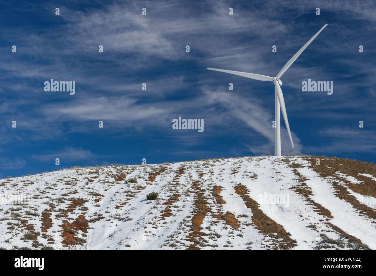 Windturbine auf einer Windmühle für die Erzeugung alternativer Energie in den schneebedeckten Tehachapi-Bergen in Südkalifornien. Stockfoto