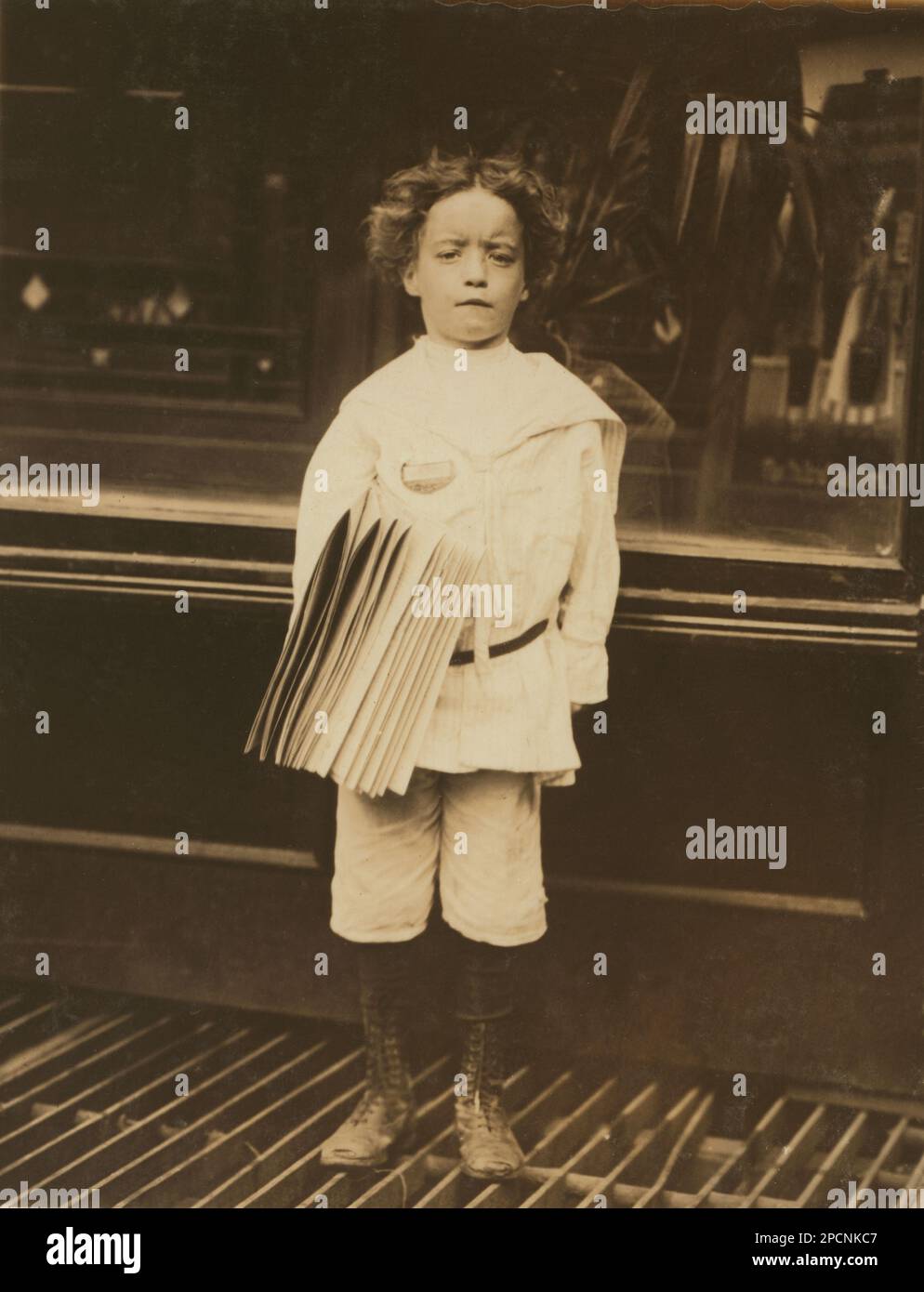 1910 , juli, NEW YORK , NEW YORK , USA : Jo. Lehman, ein 7-jähriger Zeitungsjunge. 824 Third Avenue, New York City. Er hat in diesem Friseursalon verkauft. Ich fragte ihn nach dem Abzeichen, das er trug. „Oh! Das ist mein bruder', sagte er. - NEWSBOYS , Fotos von LEWIS HINE ( 1874 - 1940 ) - - NEWSBOYS - BAMBINI -- LAVORATORI - BAMBINO - KINDERARBEITER - FABRIK - KINDHEIT - KINDHEIT - KIDNIEN - LAVORO MINORILE - LAVORO - ARBEIT - LAVORATORE - ARBEITNEHMER - OPERAIO - CLASSE OPERAIA LAVORATRICE - ARBEITERKLASSE - OPERAI - LAVORATORI - LAVORO - UNITI D' AMERICA - FOTO STORICHE - GESCHICHTE - PORTRÄT - Rituto - TEMPI MO Stockfoto