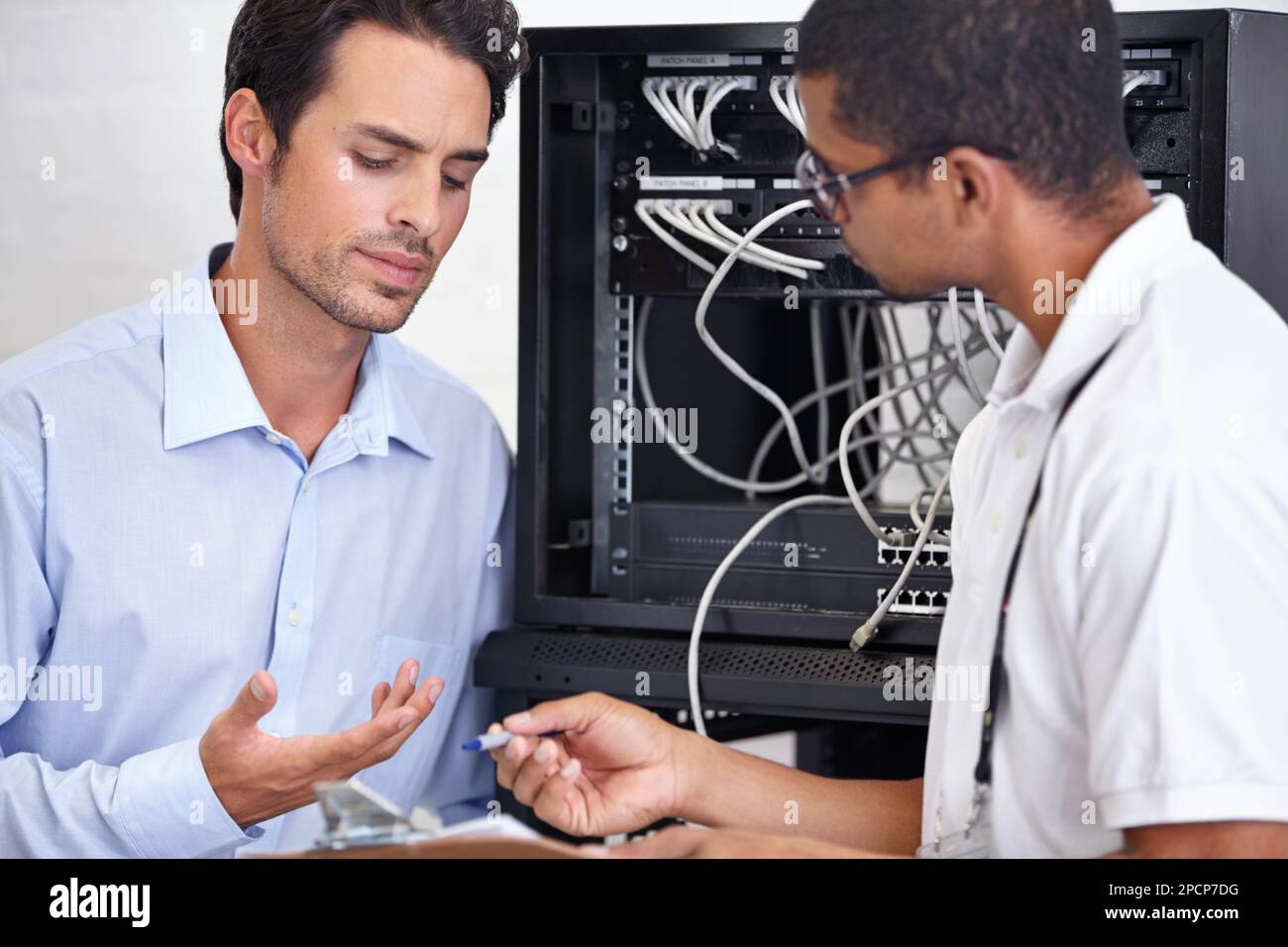 Helfen Sie mir, dies zu verstehen... Ein junger IT-Spezialist, der bereit ist, einen Server zu reparieren. Stockfoto