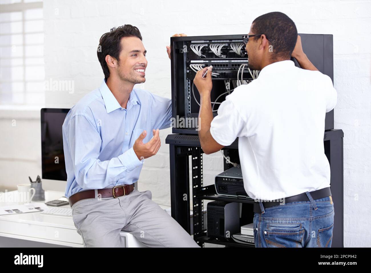 Verdrahtet für den Erfolg. Ein junger IT-Spezialist, der bereit ist, einen Server zu reparieren. Stockfoto