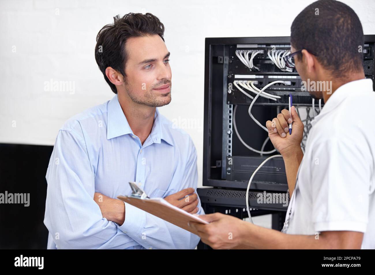 Er vertraut seinem Rat. Ein junger IT-Spezialist, der bereit ist, einen Server zu reparieren. Stockfoto