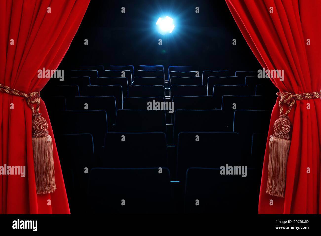 Offene, elegante rote Vorhänge und Flur mit leeren Sitzplätzen im Hintergrund Stockfoto