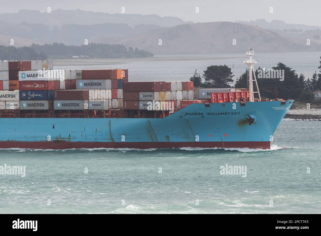 Ein beladenes Frachtschiff fährt durch eine Bucht auf der Südinsel von Aotearoa Neuseeland. Stockfoto