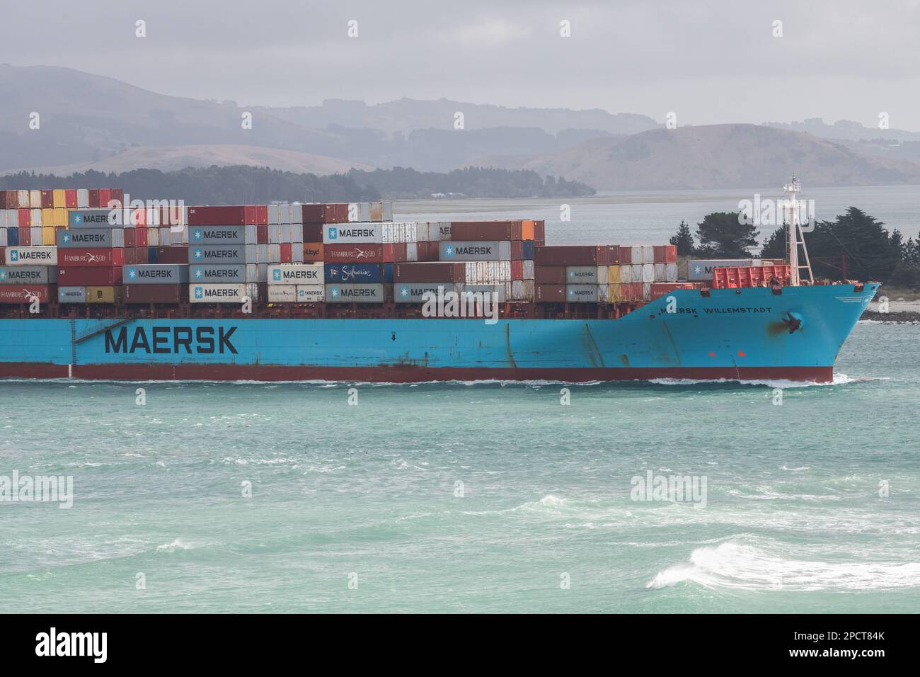 Ein beladenes Frachtschiff fährt durch eine Bucht auf der Südinsel von Aotearoa Neuseeland. Stockfoto