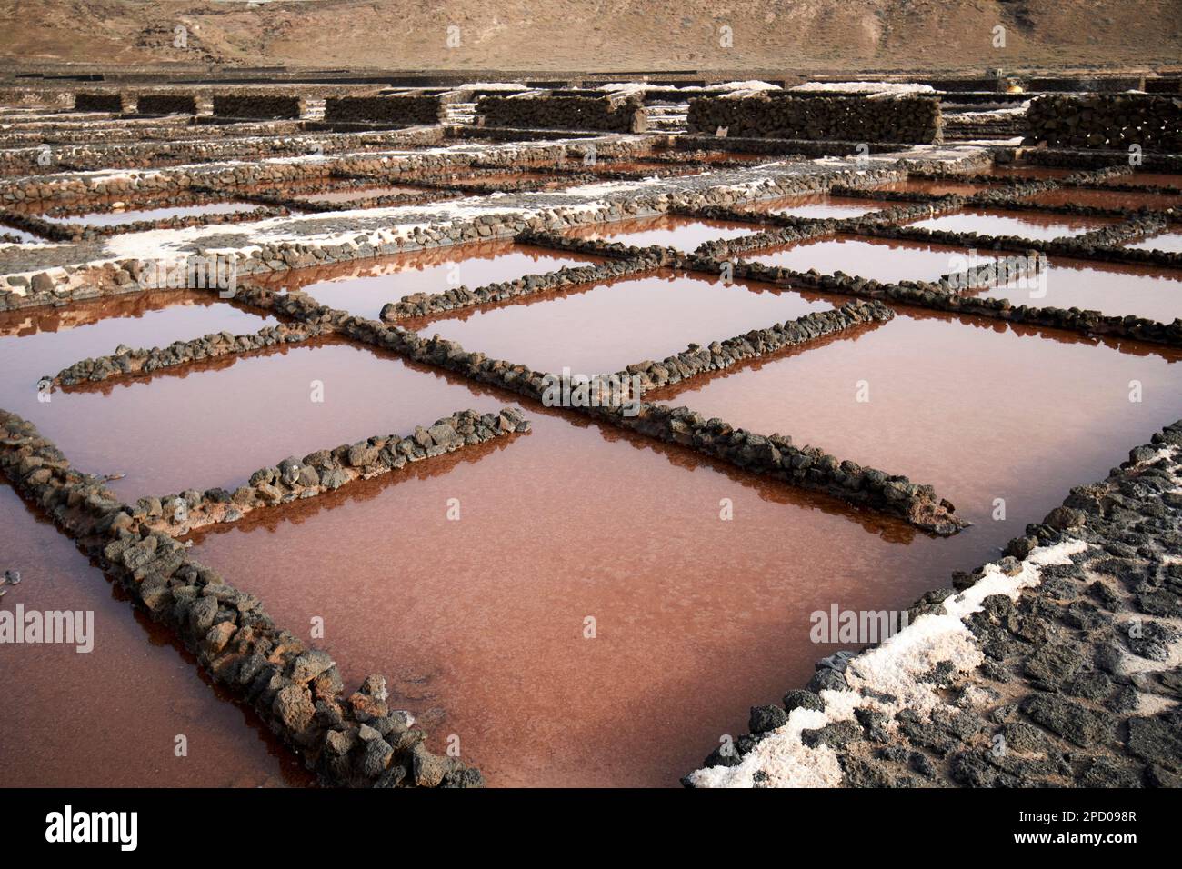 Rosafarbene, superkonzentrierte Salzwasserlösung im endgültigen Verdampferbehälter und im Aufbewahrungsbereich, in dem das Flor de Sal gesammelt wird salinas de janubio Salz flach Stockfoto